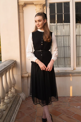 a lady in a white shirt and a black dress with a belt